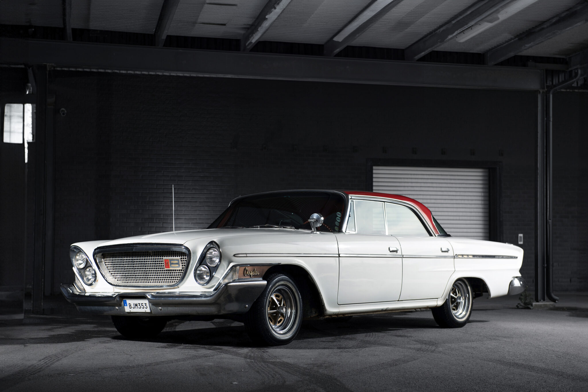 1962 Chrysler Newport 4-door hardtop in pristine condition, featured in a studio setting. Classic car with updated disc brakes, reupholstered seats, and a powerful V8 engine